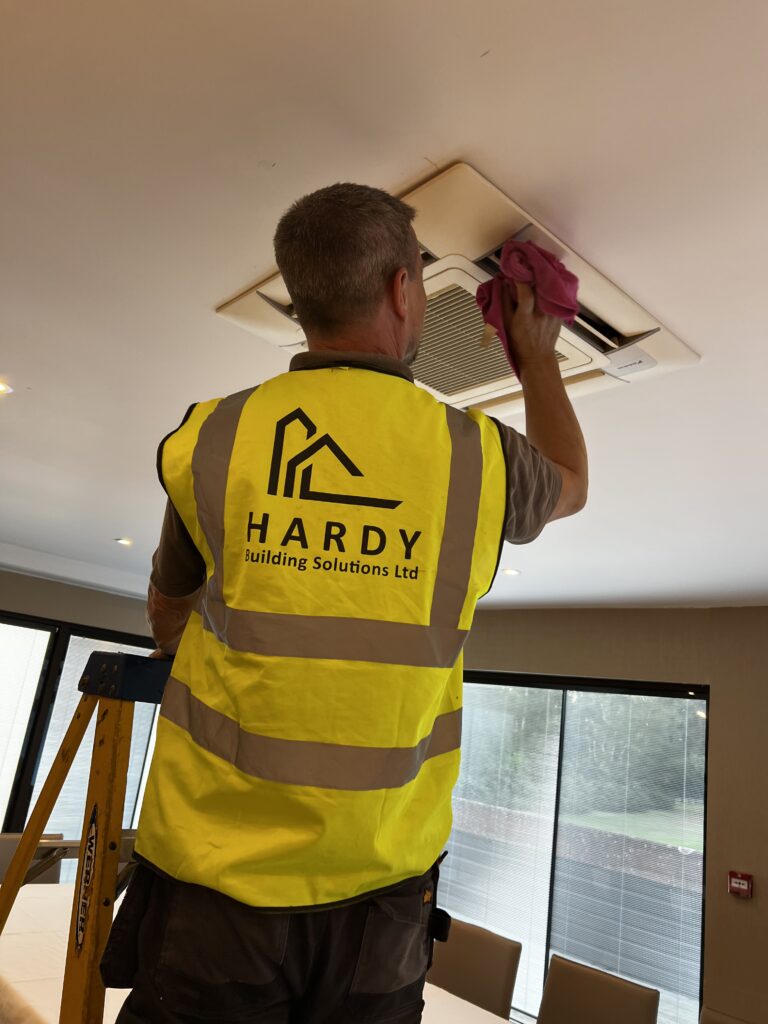 Image shows an air conditioning unit being fitted in the ceiling